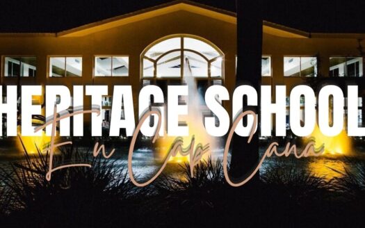 Nighttime exterior of Heritage School with a glowing fountain and bold white text reading 'HERITAGE SCHOOL' across the front.