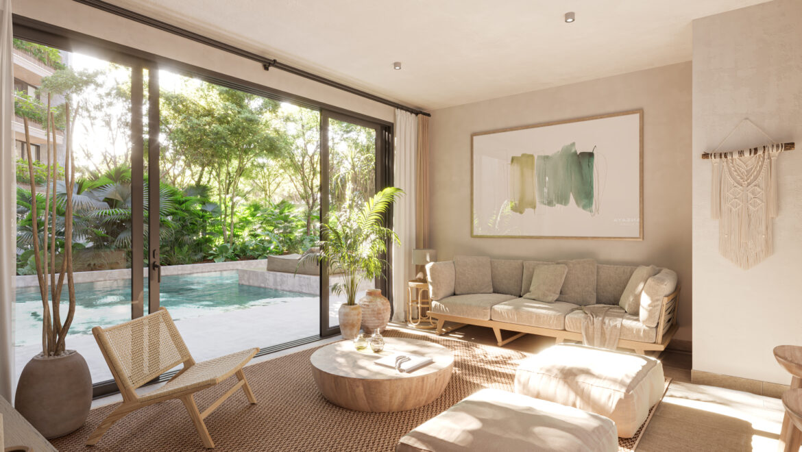 Bright living room with sliding glass doors opening to a pool and tropical garden; beige sofa, wicker chairs, and abstract wall art.