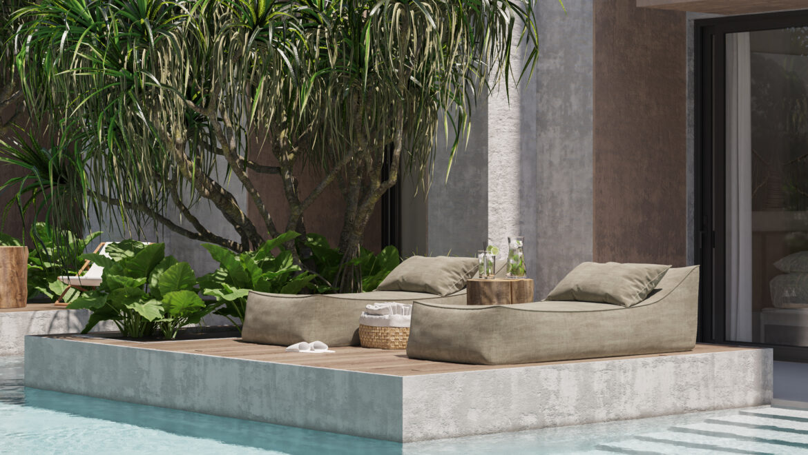 Poolside outdoor lounge with beige sectional seating, wooden coffee tables, and lush tropical plants against a modern textured wall.