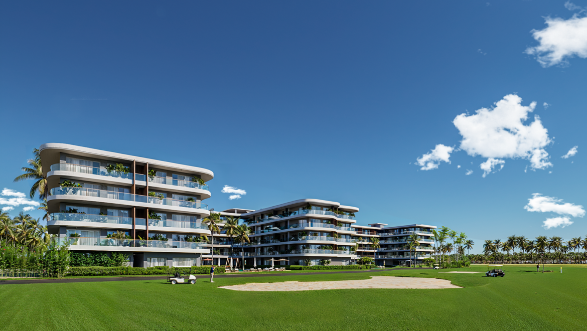 Modern multi-story apartment complex with curved balconies overlooking a green lawn and palm trees under a clear blue sky.