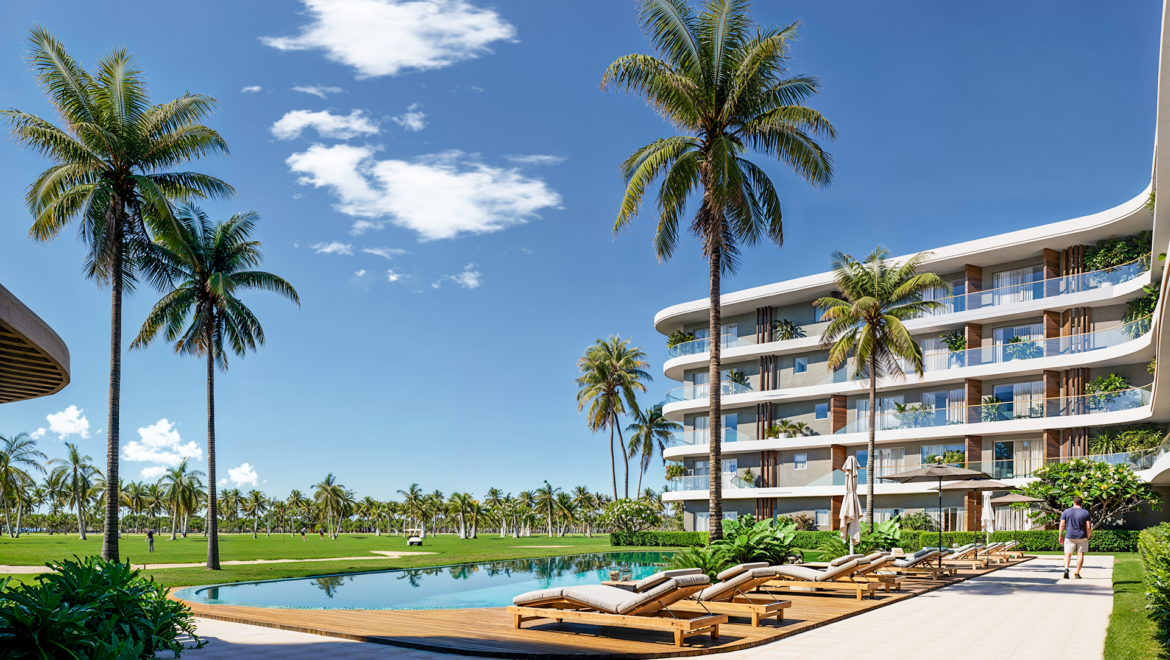 Resort building with curved balconies, palm trees, and a poolside lounge area under a blue sky