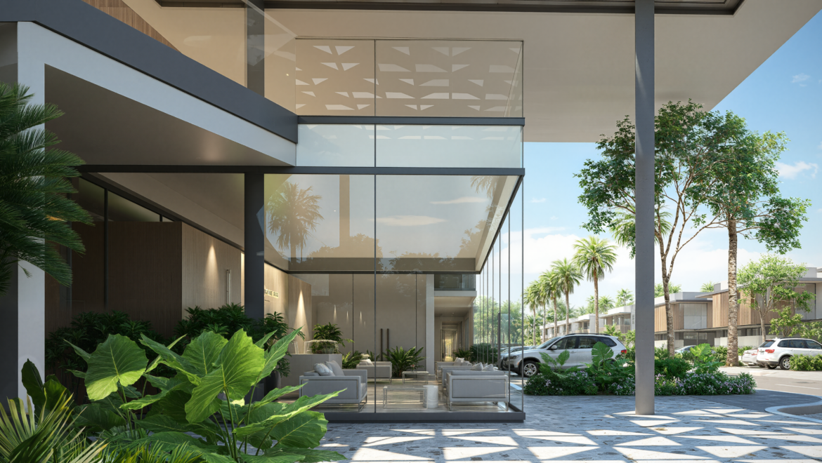 Modern glass-fronted building entrance with outdoor seating, lush tropical plants, and a parking lot nearby.