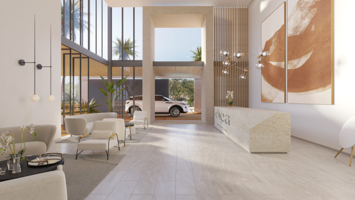 Luxurious hotel lobby with white seating, beige floors, and a car visible through the entrance under a glass facade outside.