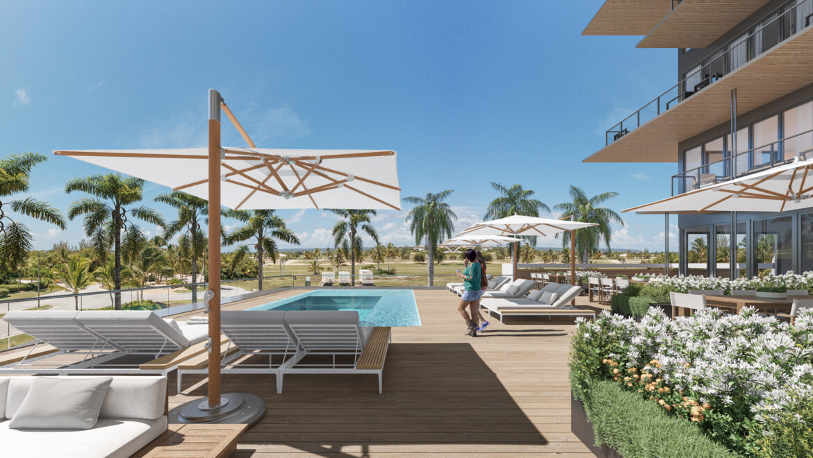 Poolside wooden deck with white lounge chairs, large white umbrellas, and palm trees under a bright blue sky.