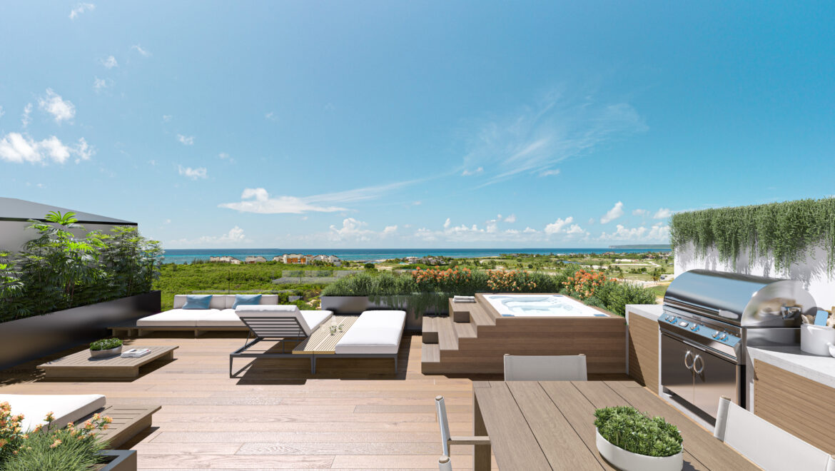 Modern rooftop terrace with white seating, wooden decking, planters, hot tub, and an ocean view in the distance.