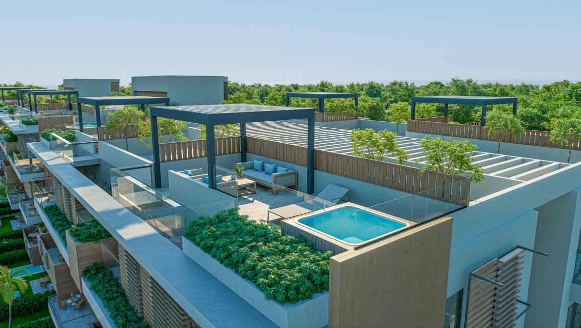 Aerial view of a modern apartment complex with rooftop terraces, glass railings, lounges, and a small pool surrounded by greenery.