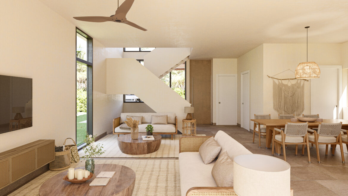 Open-plan living and dining area with cream furniture, wooden coffee tables, a woven pendant lamp, and a staircase at the back, seen through large windows revealing greenery outside.
