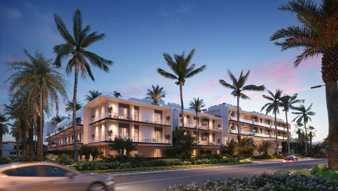 Modern white apartment building with multiple balconies, palms lining the street at dusk.