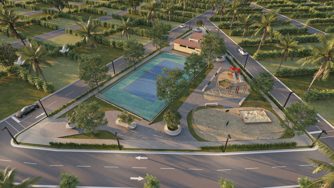 Aerial view of a palm-filled park with a blue basketball court, a small pavilion building, a playground, and surrounding roads.