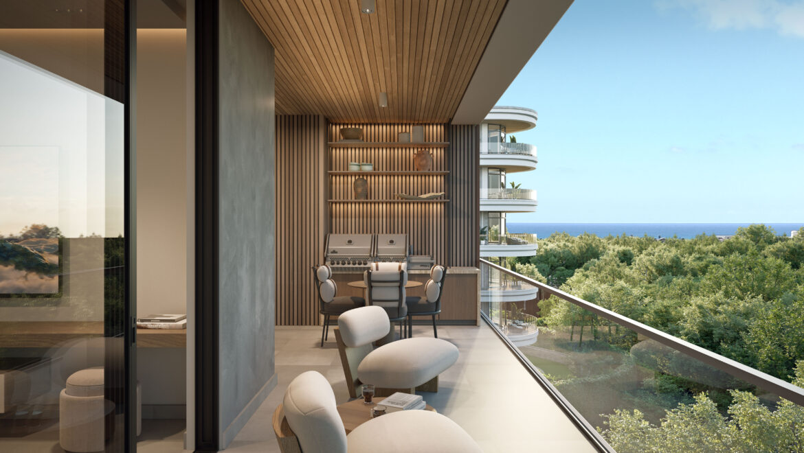 Open-air balcony with wood-clad ceiling, built-in shelves and round dining table set, overlooking the ocean and trees.