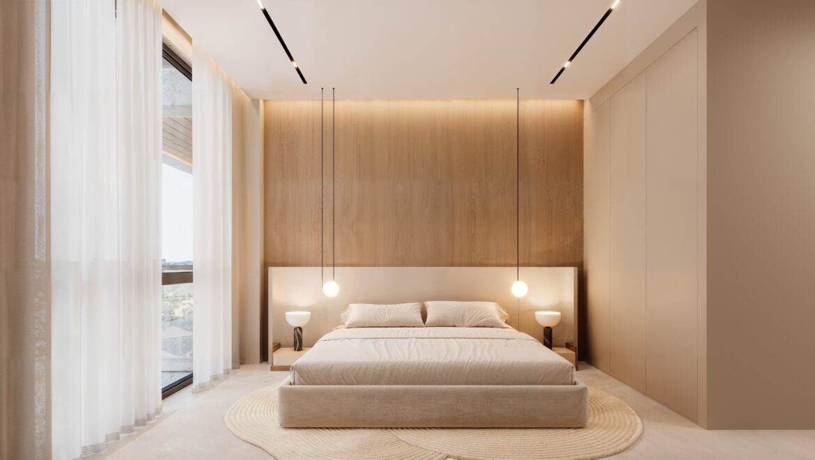 Bedroom with a low bed, beige headboard, wood-paneled wall and two pendant lamps on either side of the bed.