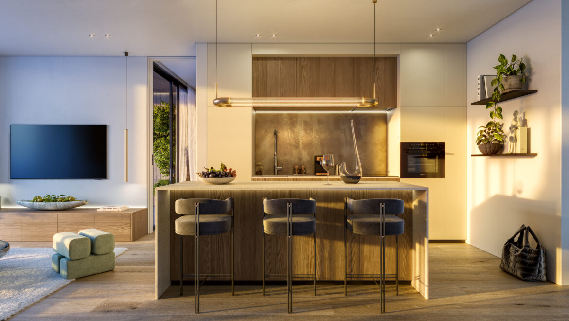 Open-plan kitchen with a central wooden island, brass bar stools, and warm pendant lighting; living area visible to the left.