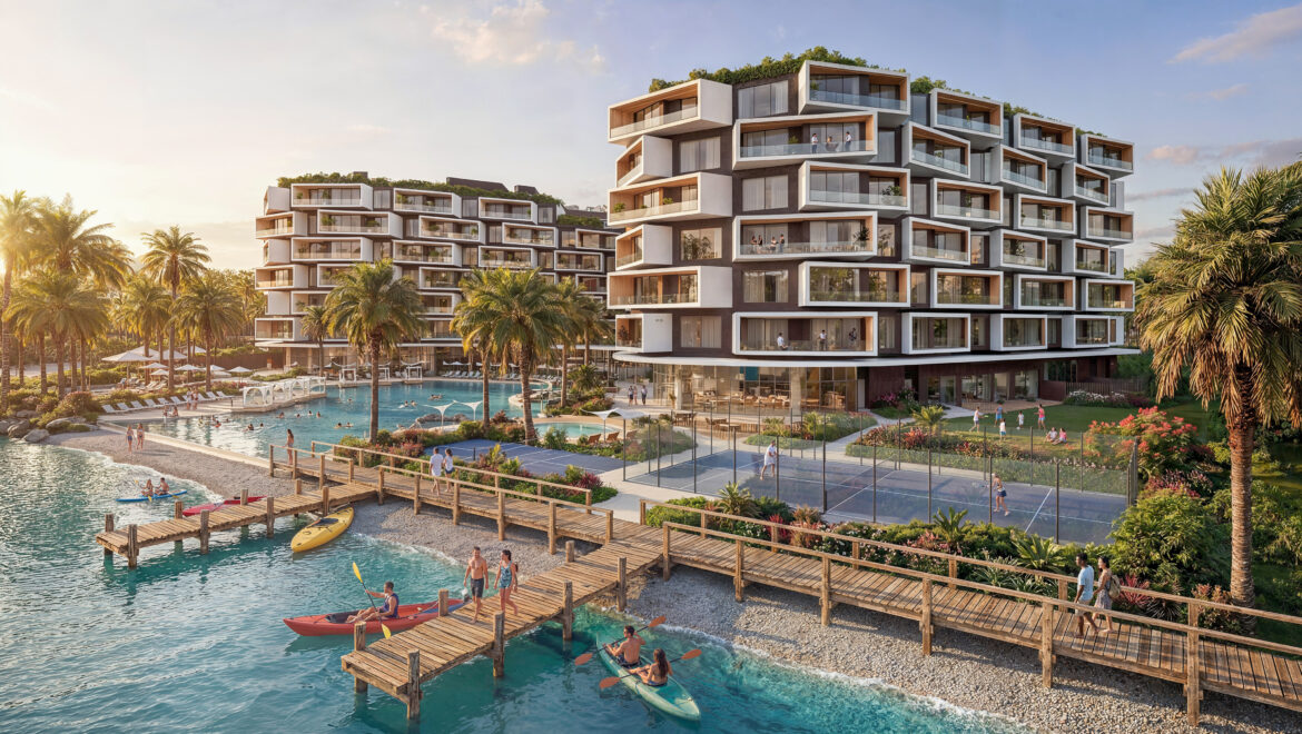 Modern waterfront residential complex with stacked cube balconies, palm trees, and a pool area by the water.