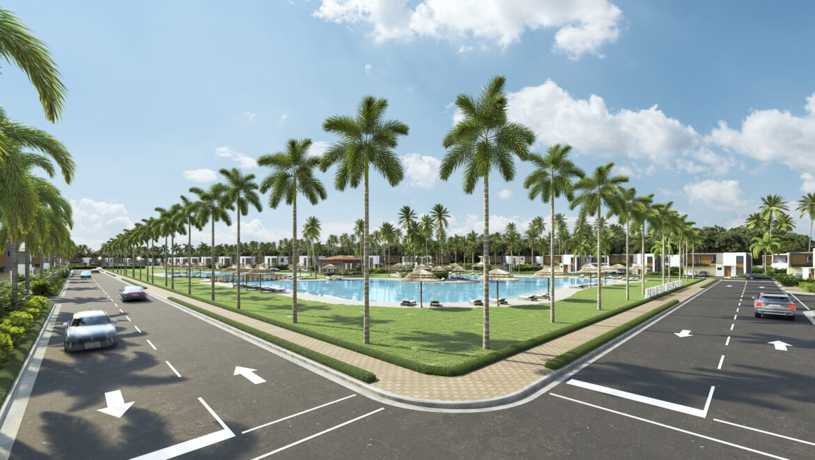 Palm-lined boulevard around a resort with a central pool, thatched umbrellas, and white villas under a bright blue sky.