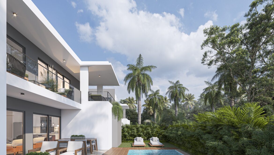 Modern white apartment building with glass balconies, wooden deck, and a pool view, surrounded by tropical trees.