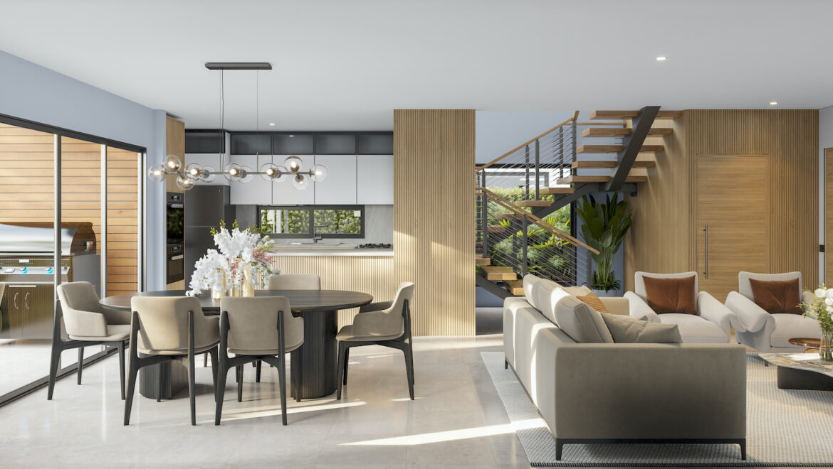 Open-concept living and dining area with a wooden staircase, gray furniture, and sliding glass doors to an outdoor grill space.